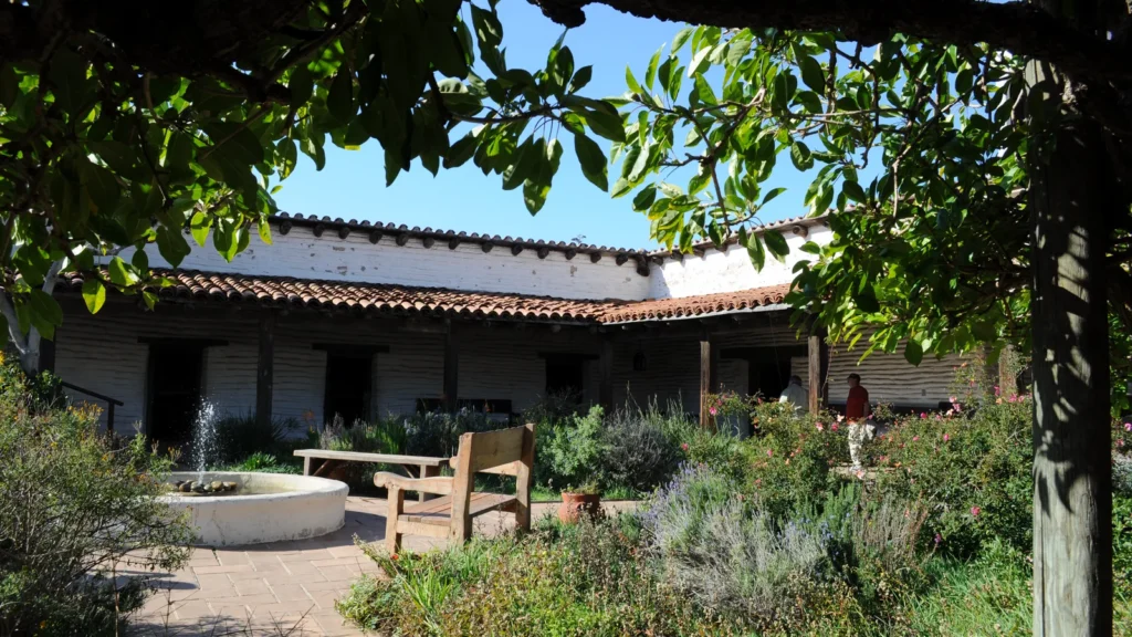 Moscas en el patio: por qué hay tantas y cómo quitarlas de raíz 1 Patio interior de una casa con plantas, suelo de ladrillo y zonas de sombra