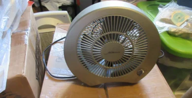 Ventilador pequeño de sobremesa funcionando sobre una caja